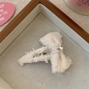 Detailopname van een witte tweed strik met hartvormige strass op een presentatiedienblad