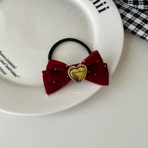 Detail eines roten Samthaarbands mit handgefertigter goldener Herzschnalle