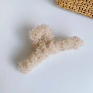 Detail einer weichen cremefarbenen Plüsch-Haarklammer mit flauschiger Pelzstruktur