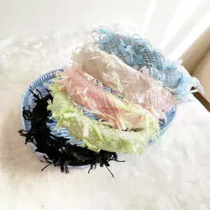 Retro tweed sponge headband in multiple pastel colors on a woven tray display