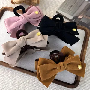 Set of four velvet bow hair claws in pink, black, beige, and caramel with fashion plaque