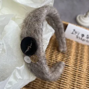 Detail of grey mohair headband with three vintage buttons and soft fuzzy texture
