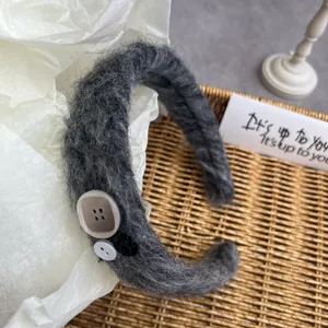 Macro shot of dark grey mohair headband featuring decorative vintage buttons
