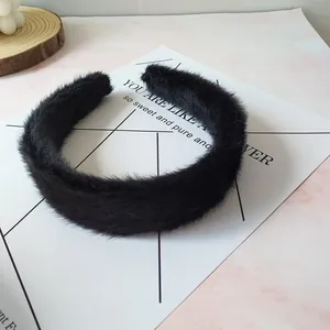 Primer plano de una diadema acolchada de felpa negra con textura suave de piel sintética