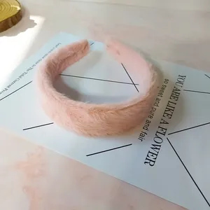 Primer plano de una diadema de felpa rosa suave con diseño de corona alta y textura