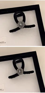 Detail of velvet shark clip with sparkling rhinestones and grey heart-shaped crystal