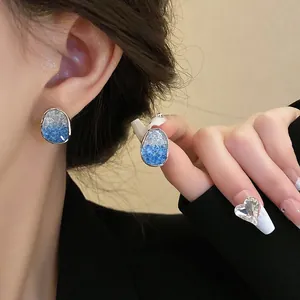 Elegant 925 silver blue gradient crystal earrings displayed on model's ear
