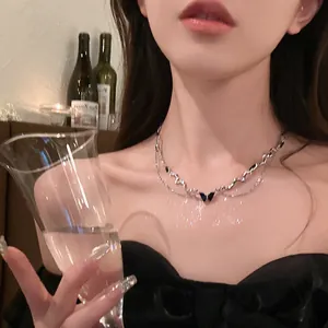 Double-layered silver necklace with dark blue butterfly pendant worn by model in elegant setting