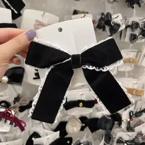 Elegant black velvet bow hair clip with white lace trim for feminine hairstyles