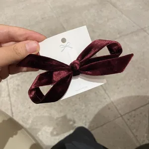 Elegant wine red velvet bow hair clip on a Korean card display for minimalist styling