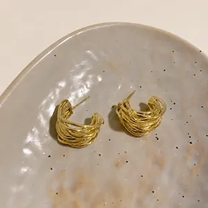 Detailed view of layered golden hoop earrings with delicate multi-strand wire design