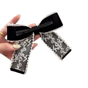 Elegant black velvet bow hair clip with white lace trim and metal duckbill clip