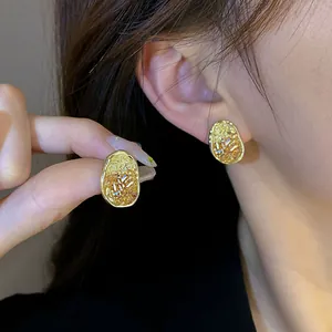 Textured gold crystal earrings for women with irregular oval shape and hammered finish