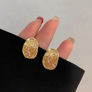 Gradient crystal stud earrings with gold oval frame and amber stone inlay for women