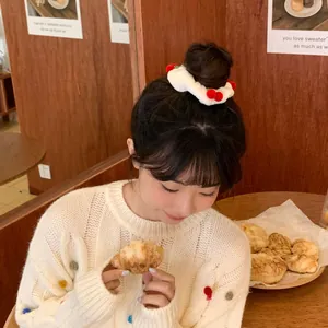 Cute white plush hair scrunchie with red cherry pom-poms for girls' winter hairstyles