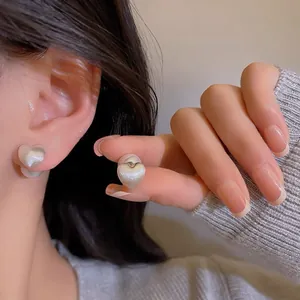Elegant silver heart-shaped pearl stud earrings with a brushed metal matte texture