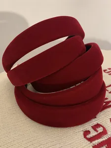 Detail shot of vintage burgundy velvet padded headband on white knitted fabric texture