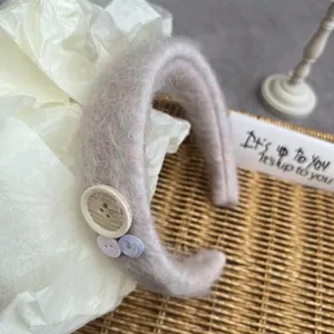 Detail of plush velvet headband with decorative wooden buttons and soft fuzzy texture