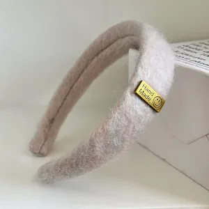 Detail eines rosa Plüsch Stirnbandes mit weichem Kunstfell und handgemachtem Tag