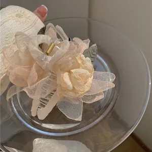 Eleganter Haarklammer mit aprikosenfarbenen Netzblumen und goldenen Metalldetails