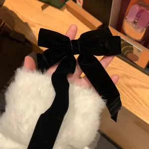 Gros plan d'un nœud papillon en velours noir à longs rubans fluides élégants