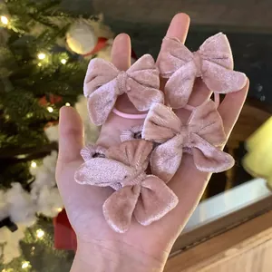 Lot de quatre chouchous nœuds en velours rose présentés dans un cadre de cadeau festif