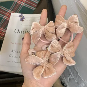 Détail du lot de 4 barrettes et chouchous en velours avec nœud en rose poudré
