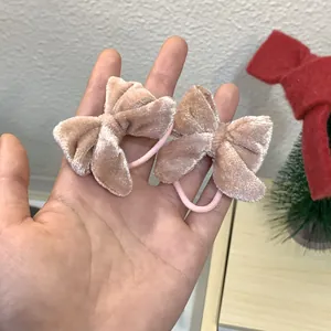 Détail d'une paire de chouchous à nœuds en velours rose avec élastiques pour le quotidien