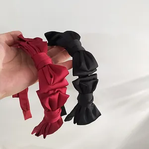 Handheld vintage velvet layered bow headbands in deep red and classic black styles