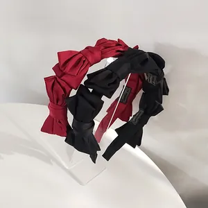 Detail of handmade vintage red and black bow headbands made of matte satin fabric