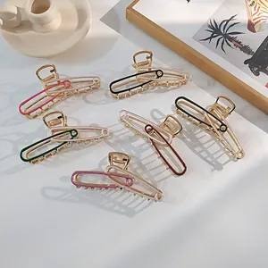 Detail van metalen haarklemmen in veiligheidsspeld-stijl in diverse kleuren op wit bureau