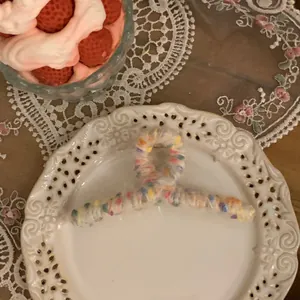 Macro view of knit claw clip with colorful tweed yarn on a decorative white porcelain plate