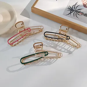 Detail van metalen haarklemmen in paperclip-vorm in de kleuren roze, zwart en groen