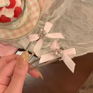 Λεπτομέρεια από δύο ροζ μεταξωτά κλιπ μαλλιών με στρας σε σχήμα καρδιάς στο κέντρο