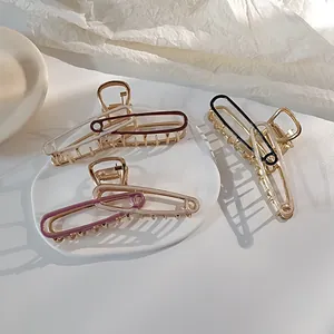 Detailopname van gouden haarklemmen in veiligheidsspeld-stijl met gekleurd email