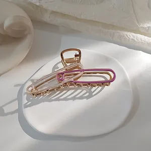 Gedetailleerde weergave van gouden paperclip haarklem met paarse en beige lak