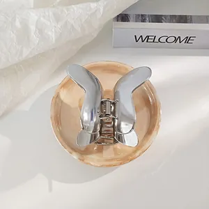 Elegant silver metal butterfly hair claw clip for women on marble base tray