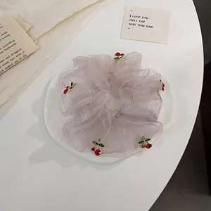Detail of pink organza scrunchie with sparkling red crystal cherry charms