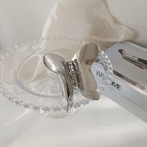 Detailed view of silver metallic butterfly hair claw clip with reflective mirror finish