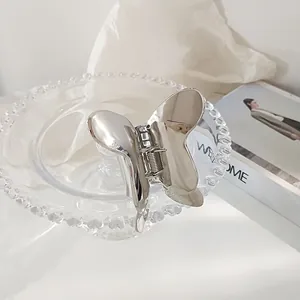 Elegant silver butterfly metal hair claw clip with polished finish on a minimalist background
