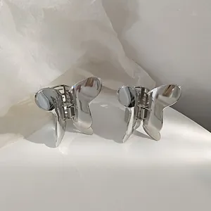 Macro shot of silver metal butterfly hair claw clips with a polished mirror finish