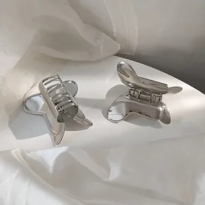 Detailed view of silver butterfly hair clips with polished metallic finish and spring mechanism