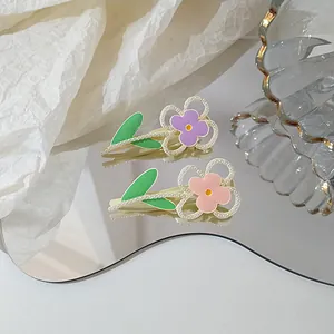 Detailed macro of two floral hair clips with pink petals and white pearl embellishments