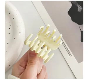 Detailed close-up of cream-colored matte hair claw clip with durable metal spring