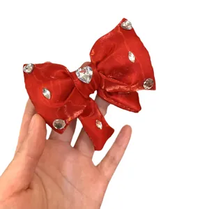 Grande fiocco per capelli in raso rosso con strass a cuore e texture setosa