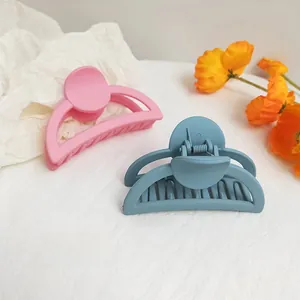 Detail view of matte finish hair claw clips in pink and blue for elegant styling