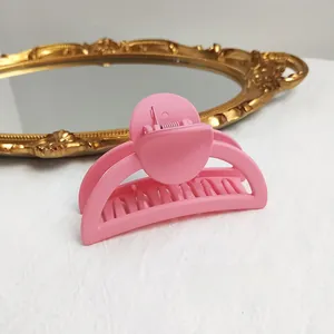 Detailed view of matte pink hair claw clip for elegant long hair styling on marble table