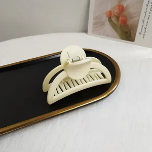 Detail of cream matte hair claw clip on an elegant tray with tulip background decor