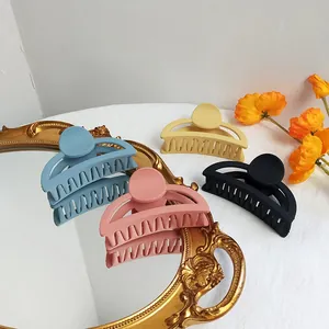 Set of four matte hair claw clips in blue pink yellow and black with hollow design