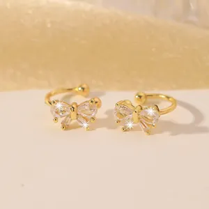 Detailansicht der goldenen Ohrmanschetten mit glitzernden Zirkonia-Schleifen